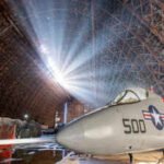 a military jet displayed inside the massive world war ii era aircraft hangar in oregon us