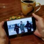 a person watches a news feed running a russias fsb security service footage of the operation to detain a japanese journalist accused of espionage on a smartphone in moscow on oct 13