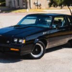 inside the gnx remains unmistakably rooted in its era a three spoke leather wrapped steering wheel sits ahead of gnx specific stewart warner instrumentation